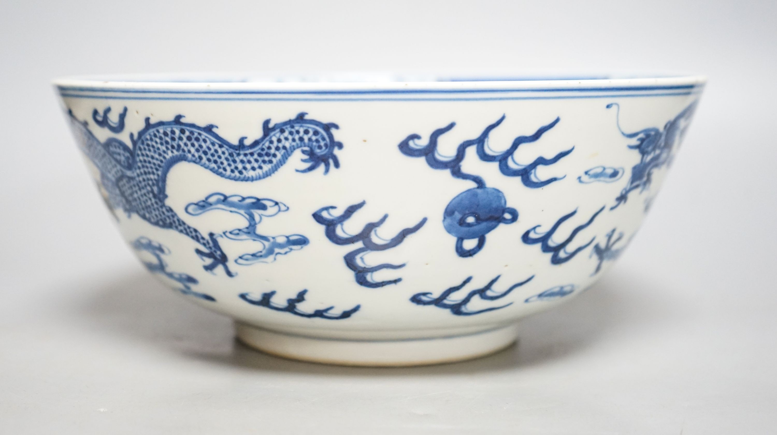 A Chinese blue and white ‘dragon’ bowl, Kangxi mark, late 19th century 25cm